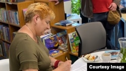 Галіна Максімюк падпісвае кніжку на аўтарскай сустрэчы ў Орлі, травень 2023