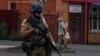 Украинский военный и местная жительница на улице города Суджи, Курская область. 16 августа 2024 года. Фото: Reuters.