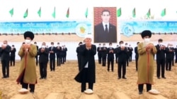 Туркменские старейшины и чиновники на фоне изображения президента Сердара Бердымухамедова, который занял пост в марте 2022 года вместо отца