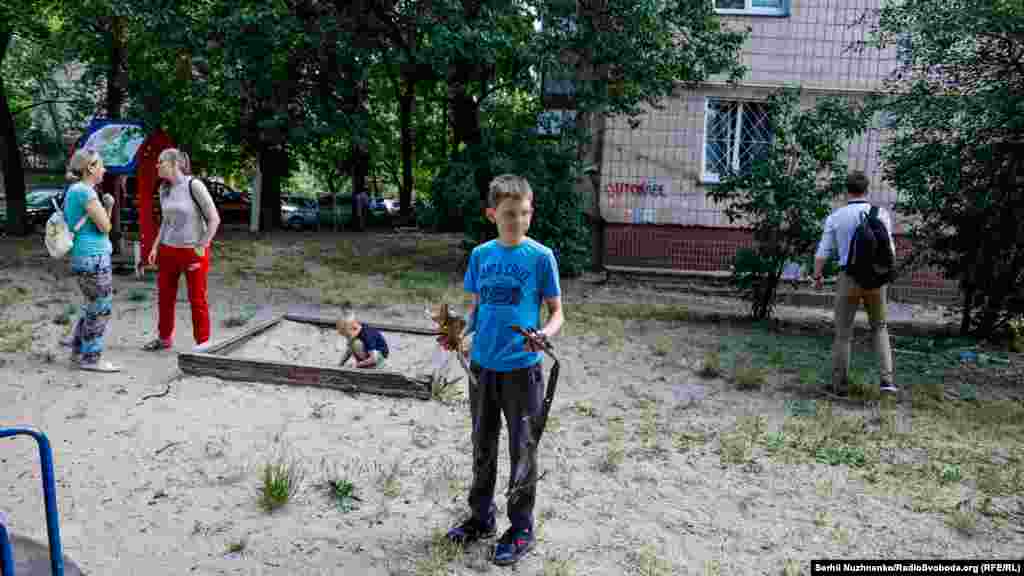 Eleven-year-old Dmytro holds the wreckage of the rocket that hit near the kindergarten.