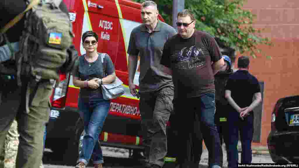 Kyiv Mayor Vitaliy Klitschko (center) also arrived at the scene.&nbsp;Klitschko called the attacks on Kyiv an attempt by Russia to &quot;intimidate Ukrainians&quot; ahead of a NATO summit slated for Madrid on June 28-30. Klitschko said one person was killed and six were injured, including a 7-year-old, who was in stable condition after surgery. The condition of her mother, who was also hospitalized, was much more serious, Klitschko said on Telegram.