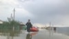 Спасатели помогают жителям села Оргебас добраться к домам на лодке, чтобы забрать документы.