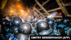Forțele speciale Berkut ale poliției ucrainene atacând o baricadă în Kiev în decembrie.