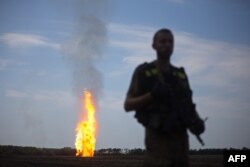 Un militar ucrainean în apropierea unei conducte de gaz distruse de separatiști lângă Avdiika.