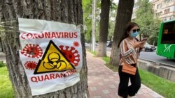 Девушка в защитной маске идет по улице Алматы. 22 июня 2020 года.