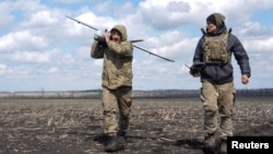 Ukrajinski vojnik nosi izviđačku bespilotnu letjelicu (UAV) prije preleta položaja ruskih trupa u blizini grada Pokrovska na frontu u Donjeckoj oblasti.