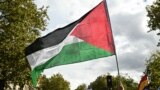 A protester waves a Palestinian flag during a march asking for the "recognition of the State of Palestine and the end of the genocide", in Paris on September 21, 2025.