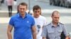 Алексей Навальный в сопровождении полицейского прибывает на слушания