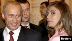 Президент Владимир Путин рядом с гимнасткой Алиной Кабаевой во время встречи с олимпийской сборной России в Московском Кремле. 4 ноября 2004 года.