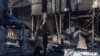 A man stands among debris next to a building destroyed after a drone attack in Odesa on March 8. 