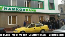 Узбекистанцы стоят в очереди у двери «Хамкорбанка», чтобы получить денежные переводы через систему Western Union. 