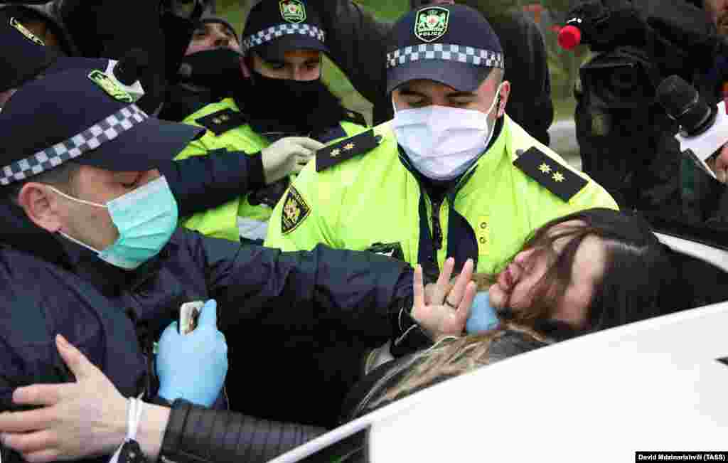 Polițiștii din capitala Georgiei, Tbilisi, îi rețin pe susținătorii partidului de opoziție &bdquo;Con de Pin&rdquo; (Girchi) pe 23 aprilie, în timp ce protestează împotriva extinderii stării de urgență în țară.