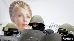 Demonstranți în Kiev, pe 8 febr., purtând un portret al Iuliei Timoșenko.