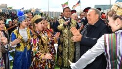 Нурсултан Назарбаев, тогда еще президент Казахстана, в окружении одетых в национальные костюмы людей на мероприятии в столице в День единства народа Казахстана. 1 мая 2018 года.
