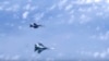 Винищувач Су-27 російських ВПС (знизу) маневрує на тлі військового літака НАТО F-18 над Балтійським морем. Архівне фото
