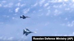 Винищувач Су-27 російських ВПС (знизу) маневрує на тлі військового літака НАТО F-18 над Балтійським морем. Архівне фото