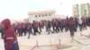 Люди в рабочей спецовке стоят на центральной площади города Жанаозен в день беспорядков 16 декабря 2011 года. Скриншот с видеопортала «Стан.кз».
