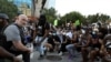 Полицейские опустились на колено вместе с протестующими во время акции протеста из-за гибели после задержания полицией афроамериканца Джорджа Флойда, Атланта, 1 июня 2020 года.