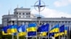 Drapelele Ucrainei și ale UE sub logo-ul NATO, în Piața Europeană din centrul Kievului (imagine de arhivă).