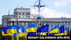 Drapelele Ucrainei și ale UE sub logo-ul NATO, în Piața Europeană din centrul Kievului (imagine de arhivă).